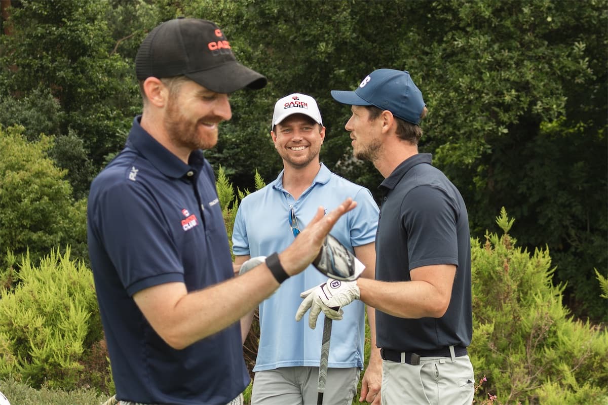 Three Caddi Club members high-fiving on a members' day out on course